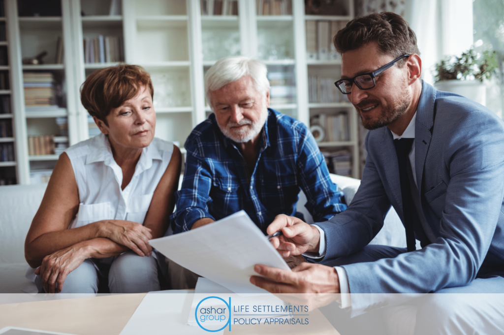 image of senior couple sitting in their home looking over papers with a financial advisor