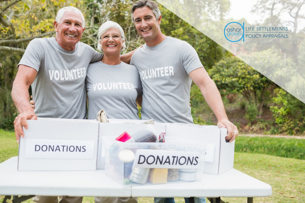 3 retired seniors wearing shirts that say “volunteer” collecting donations in boxes