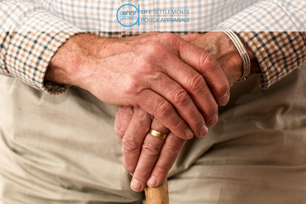 senior man in long-term care with folded hands on top of walking stick